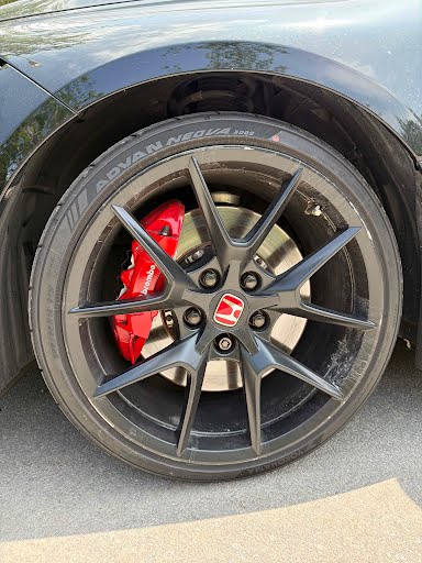 Black Honda performance wheel with scuffs and curb rash around the barrel edge