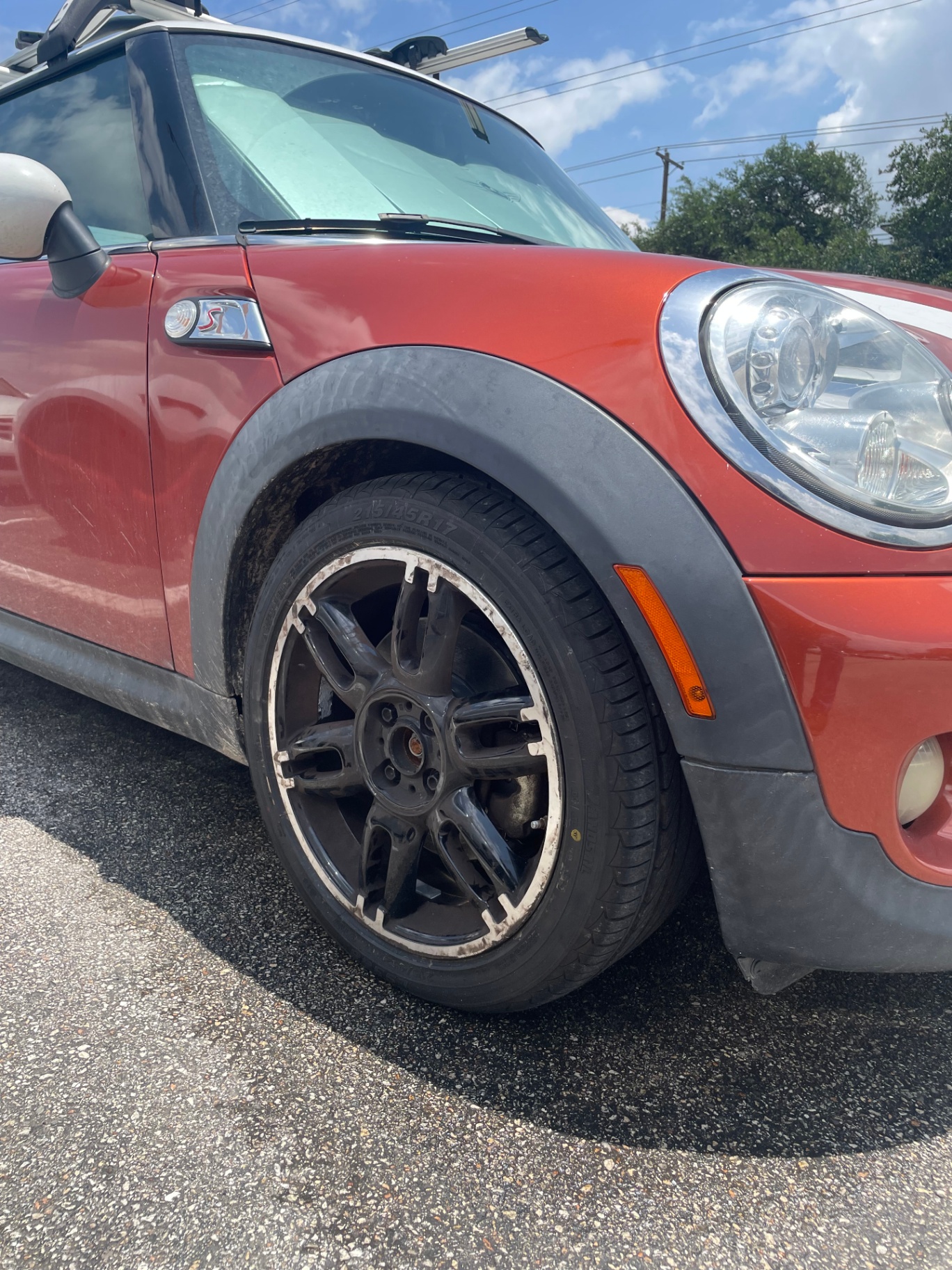 Mini Cooper black wheel with severe peeling paint around the entire lip