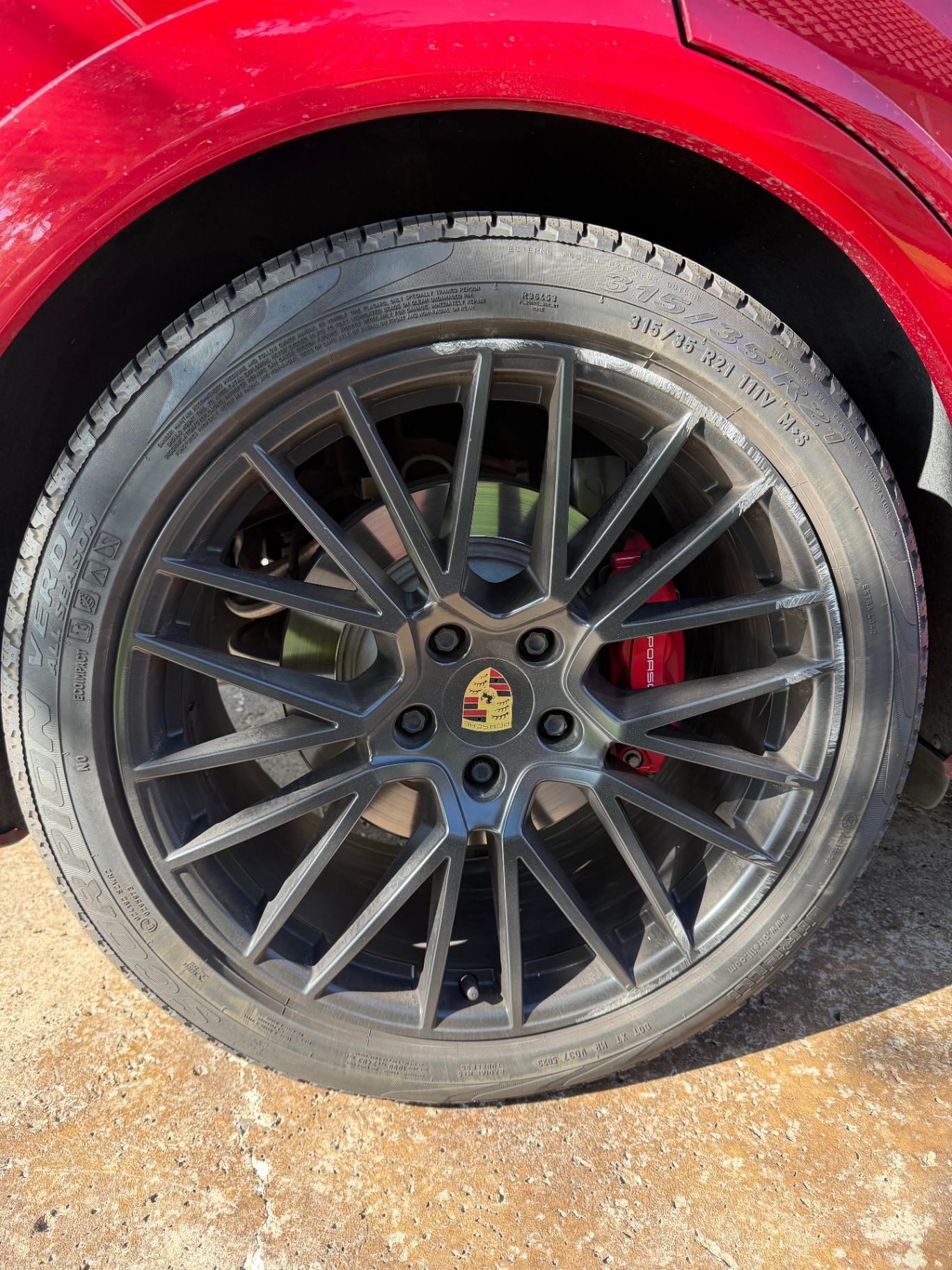 Porsche 21-inch wheel with deep curb gouge across the outer edge