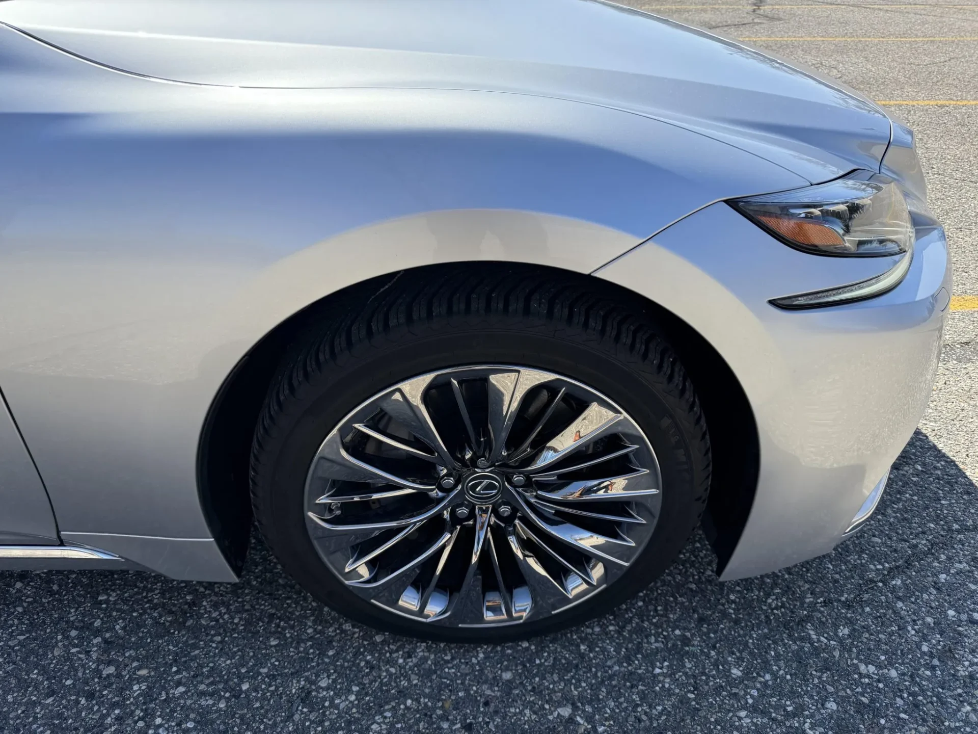 Lexus chrome wheel showing curb damage along the outer spokes and rim